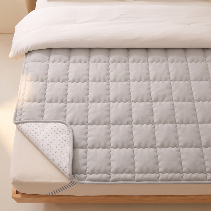 Quilted Mattress Pad in Light Gray – high-angle view of square quilting and dotted underside