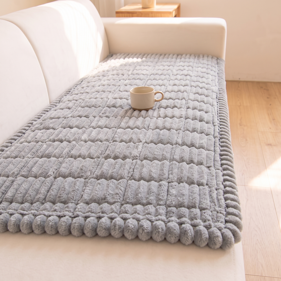 Quilted Plush Couch Cover – Ribbed in Light Gray – cream mug resting on top, showing bobble edge trim