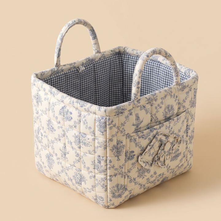 Quilted Fabric Storage Basket with Handles in Blue – Toile – raised side angle with ruffled pocket on right panel, gingham lining showing