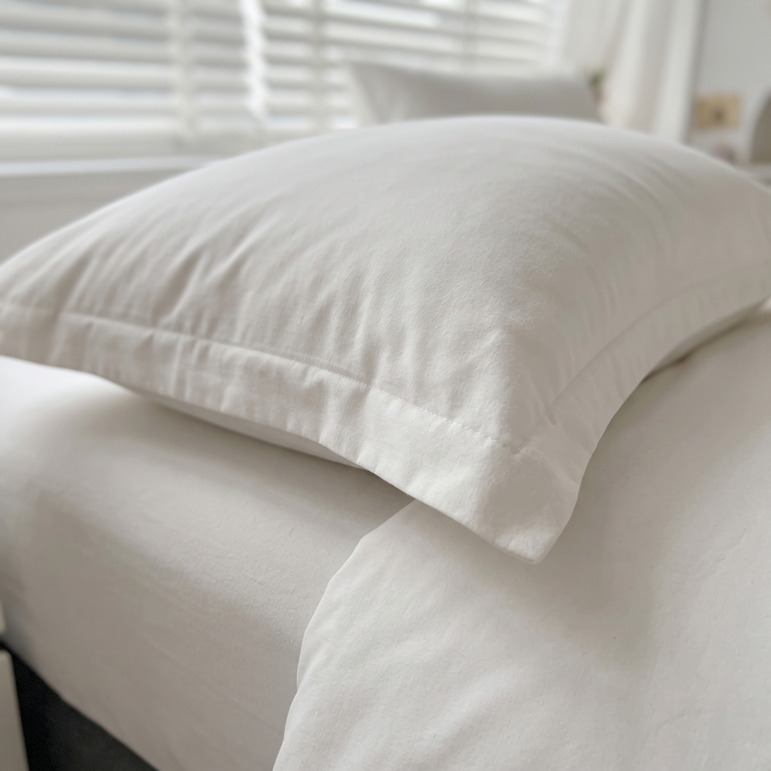 Reversible Duvet Cover Set – Two-Tone in White – close-up of a pillow with flanged edge on a bed