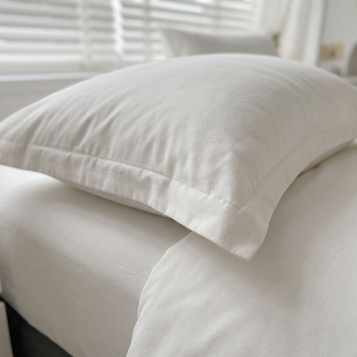 Reversible Duvet Cover Set – Two-Tone in White – close-up of a pillow with flanged edge on a bed