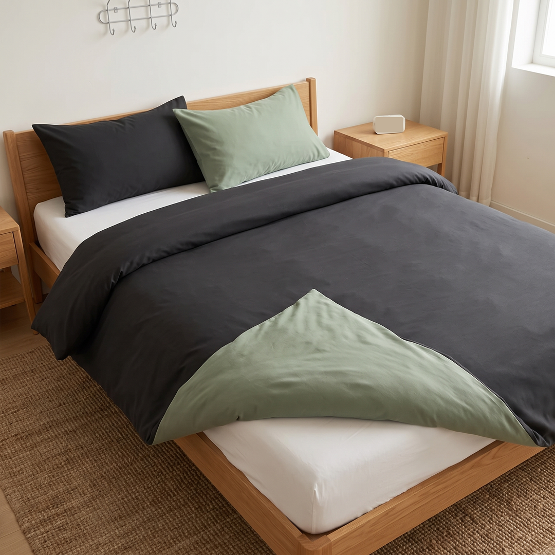 Reversible Duvet Cover Set – Two-Tone in Dark Gray &amp; Sage – high view from the foot of the bed over a woven jute rug