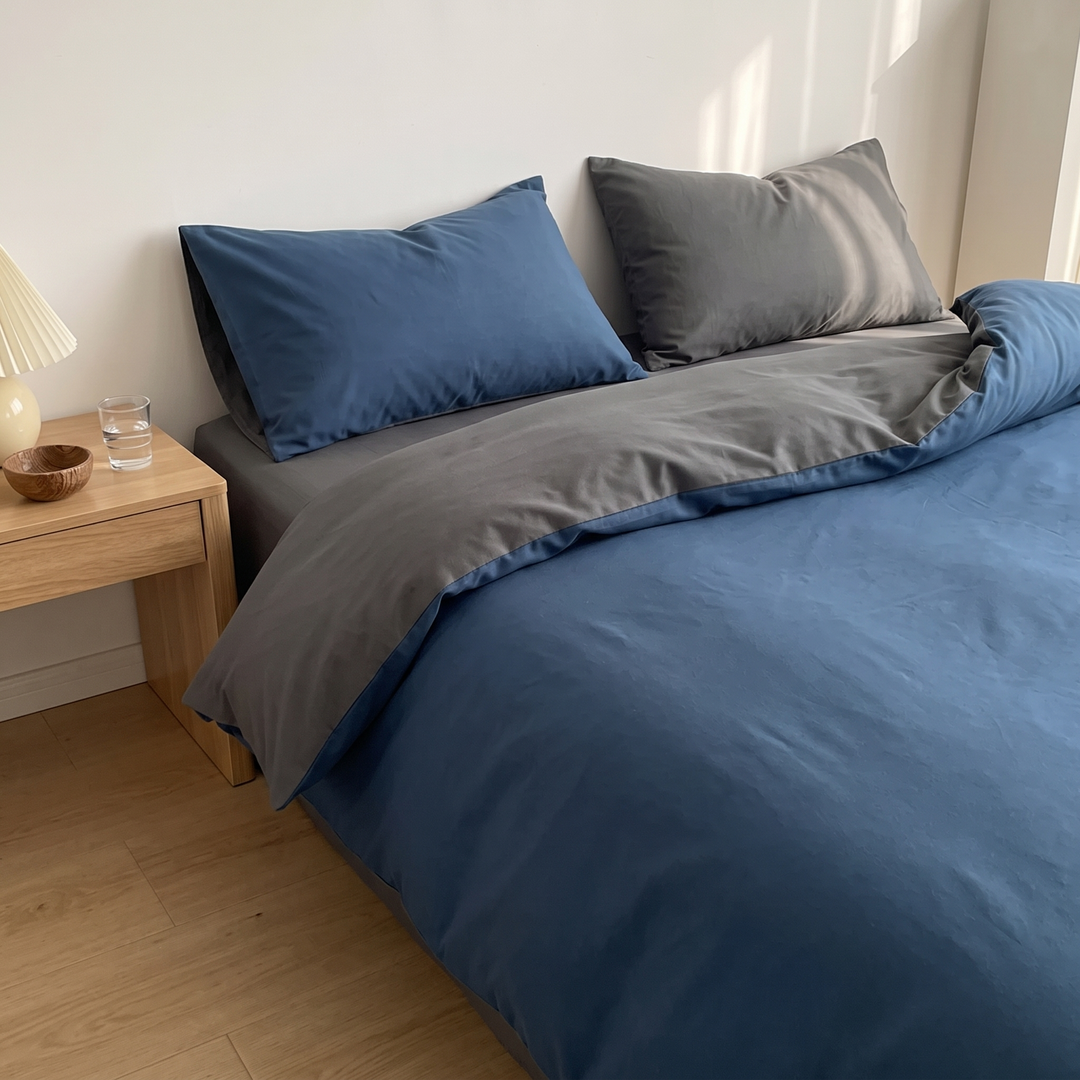 Reversible Duvet Cover Set – Two-Tone in Navy Blue &amp; Dark Gray – corner view of bed with nearby lamp and water glass