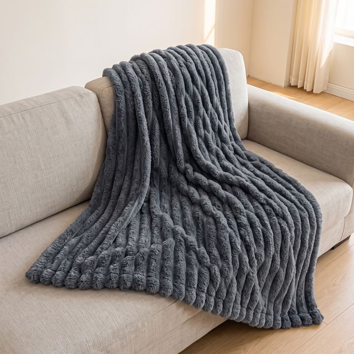 Faux Fur Throw Blanket – Ribbed Plush in Dark Gray – spread full length over a sofa in a sunlit room
