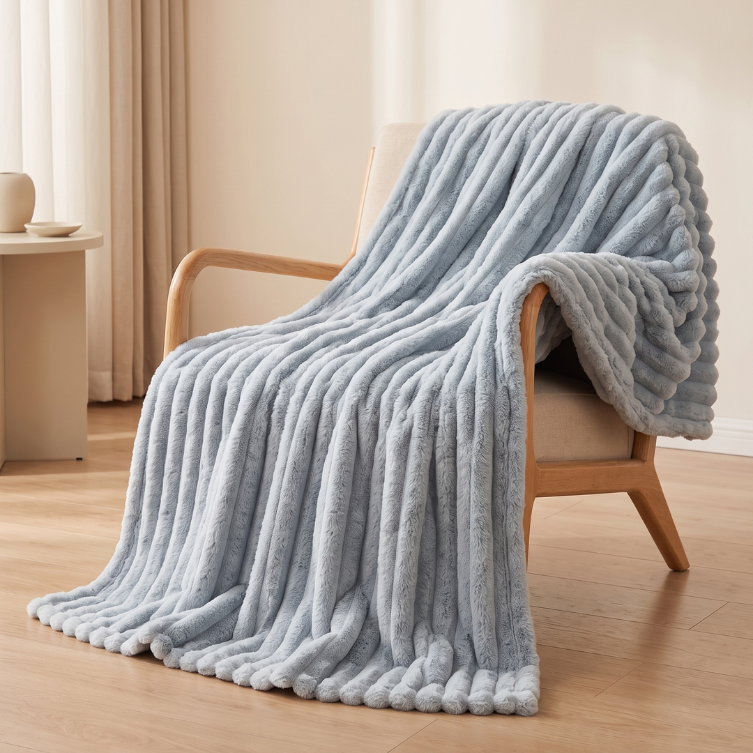 Faux Fur Throw Blanket – Ribbed Plush in Dusty Blue – draped over a wooden armchair on a hardwood floor