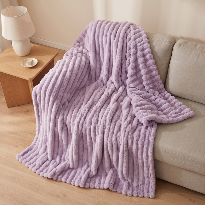Faux Fur Throw Blanket – Ribbed Plush in Lavender – spilling off a sofa onto the floor, high angle