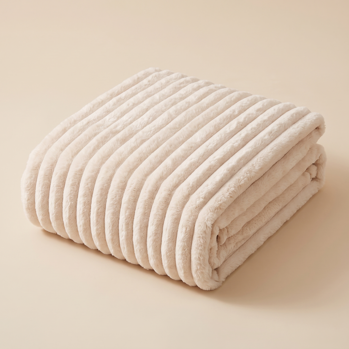 Faux Fur Throw Blanket – Ribbed Plush in Cream – folded in a neat stack on a plain beige background