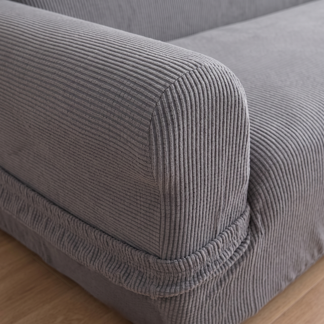 Ribbed Stretch Couch Cover in Gray – close-up of the ribbed fabric on a sofa armrest