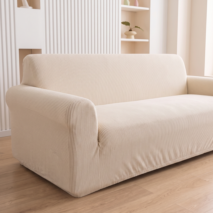 Ribbed Stretch Couch Cover in Cream – three-quarter side view against slatted wall with plant shelf