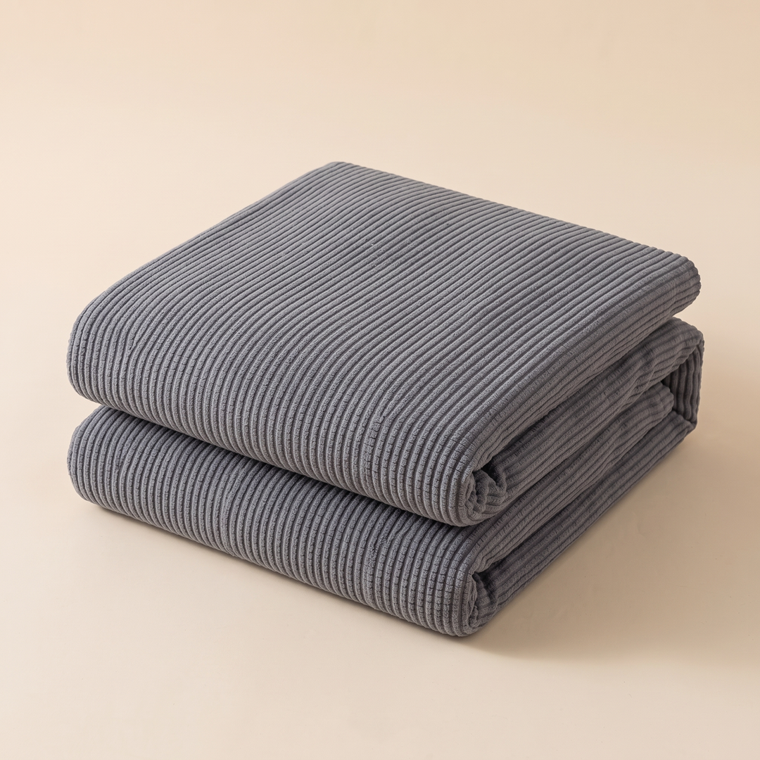 Ribbed Stretch Couch Cover in Gray – folded stack against a plain beige studio backdrop