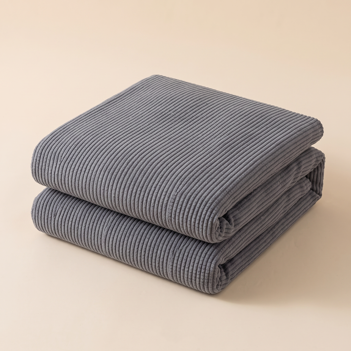 Ribbed Stretch Couch Cover in Gray – folded stack against a plain beige studio backdrop