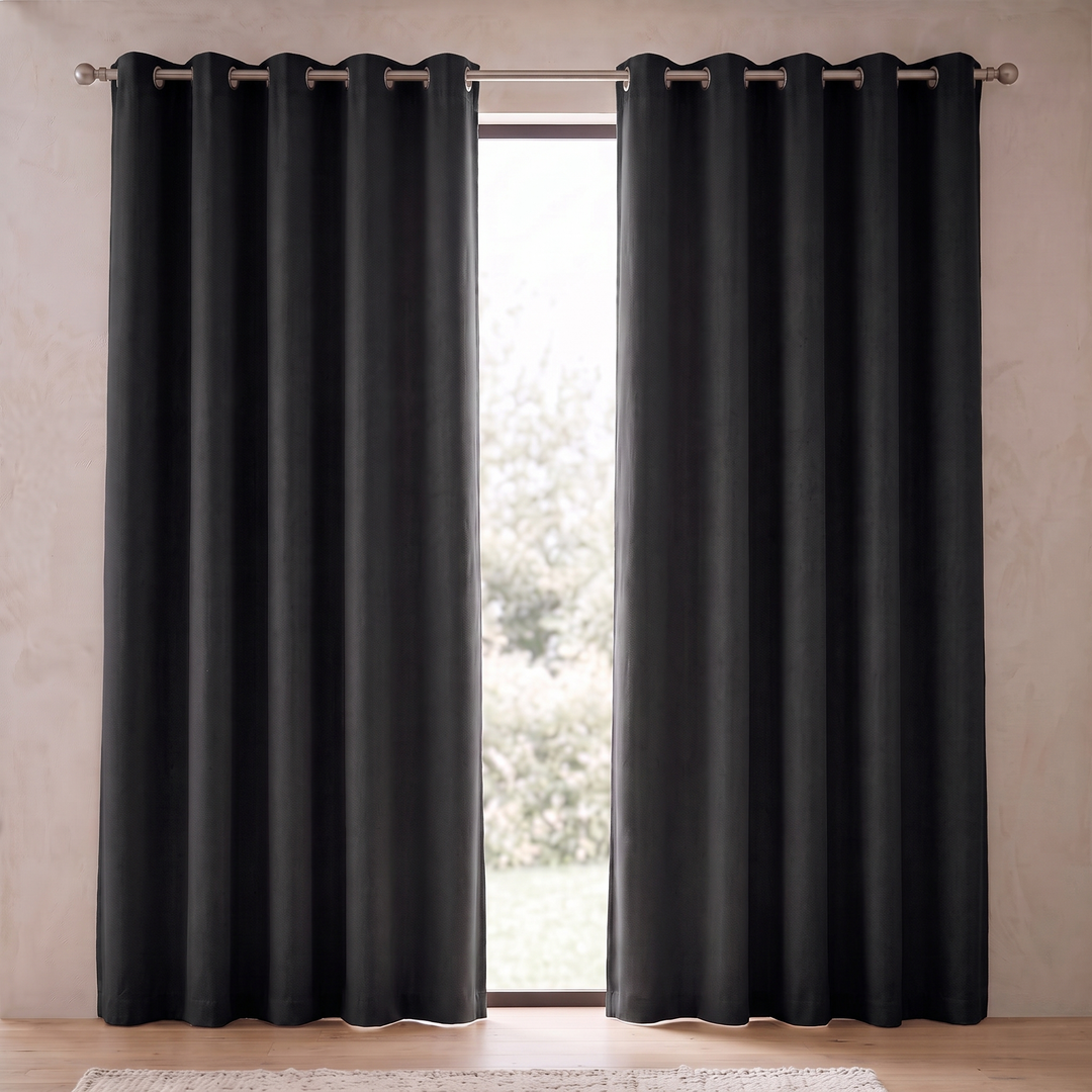 Room Darkening Curtain Panel – Grommet Top in Black – parted panels framing a narrow window, rug at bottom