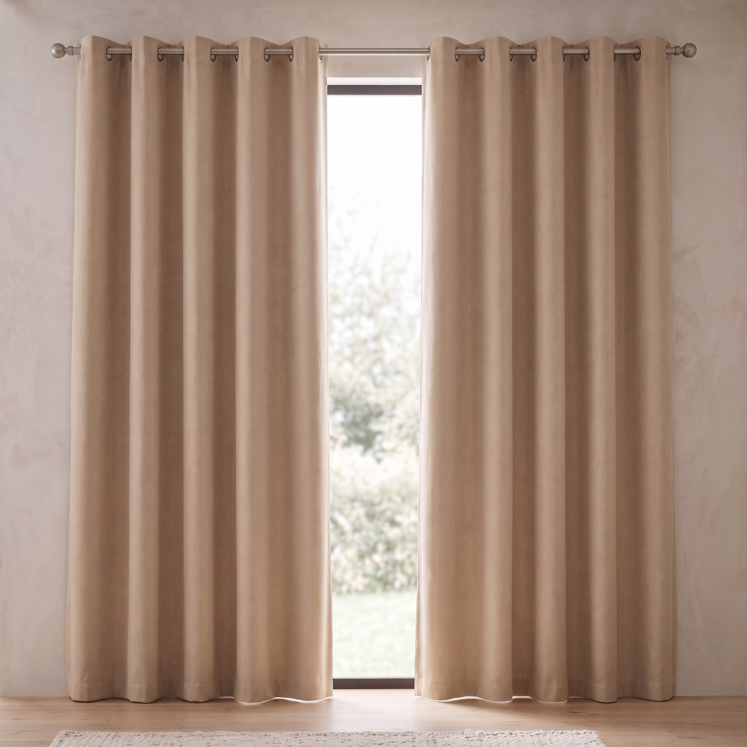 Room Darkening Curtain Panel – Grommet Top in Beige – pair hung on a metal rod beside a bright garden window