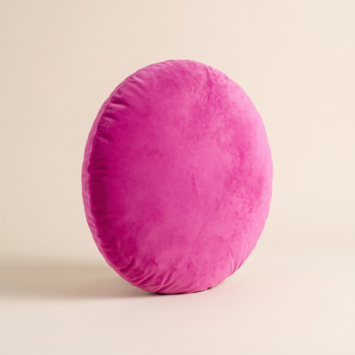 Round Velvet Pillow Cover in Fuchsia – standing on its rim with crushed velvet nap catching the light