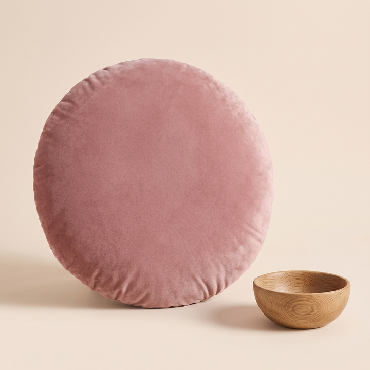 Round Velvet Pillow Cover in Rose – standing upright next to a small wooden bowl