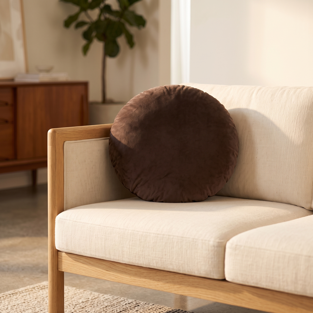 Round Velvet Pillow Cover in Chocolate Brown – on a cream linen sofa with oak frame in a living room