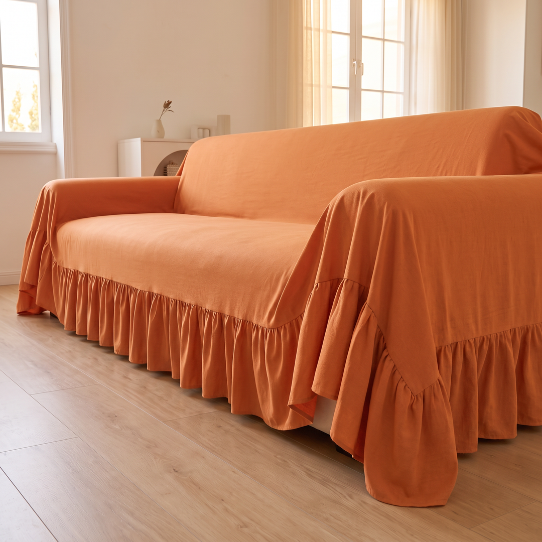 Ruffled Couch Cover in Orange – sofa end view with sunlit sheer curtains behind