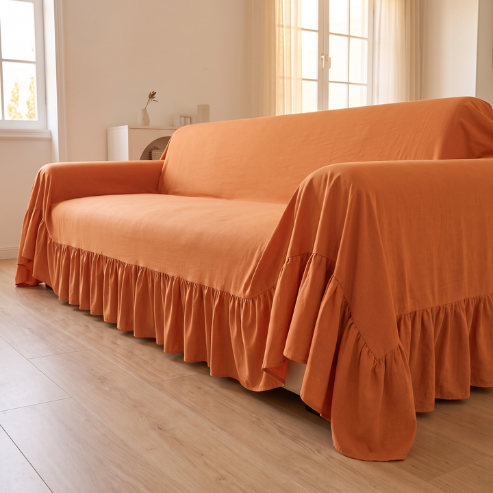 Ruffled Couch Cover in Orange – sofa end view with sunlit sheer curtains behind