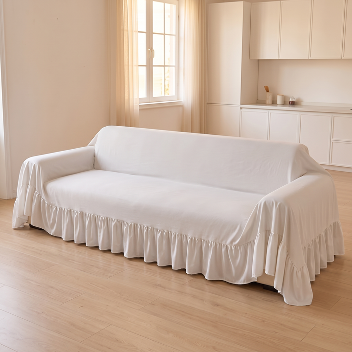 Ruffled Couch Cover in White – angled view on sofa near window and kitchen cabinets