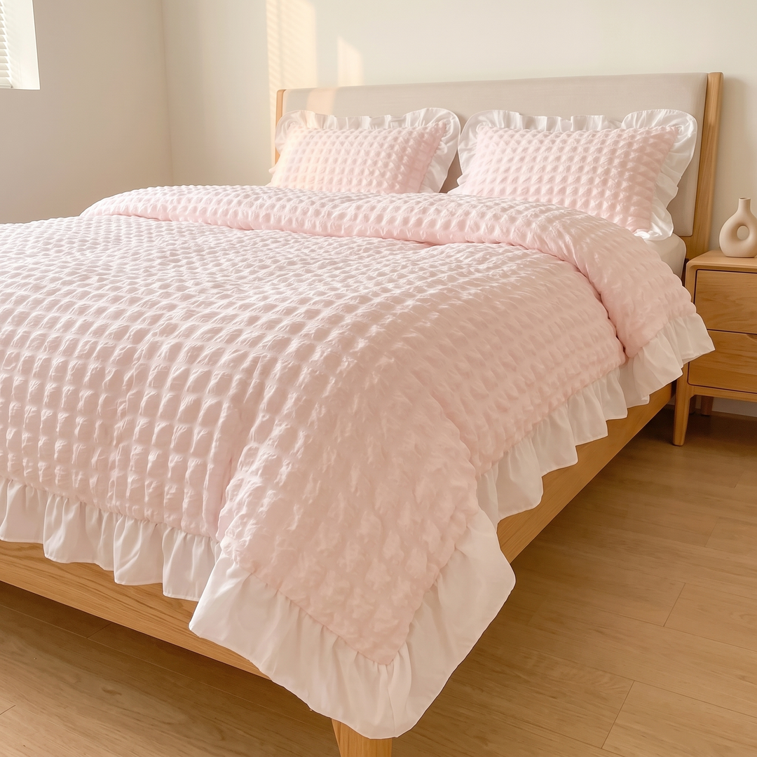 Ruffled Duvet Cover Set in Light Pink – angled view of ruffled hem beside wooden nightstand