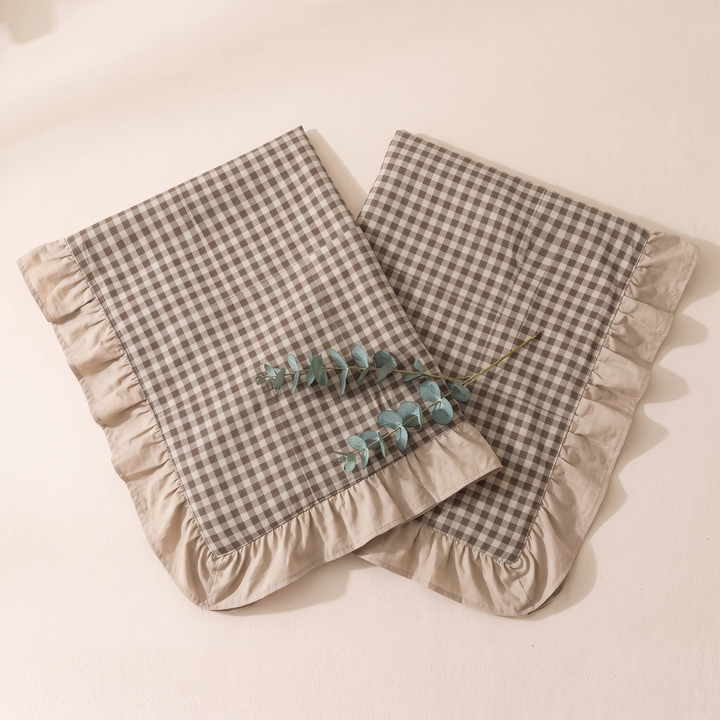 Cotton Pillowcases – Ruffled Plaid, Set of 2 in Beige Gingham – side by side, eucalyptus sprig resting across the front case