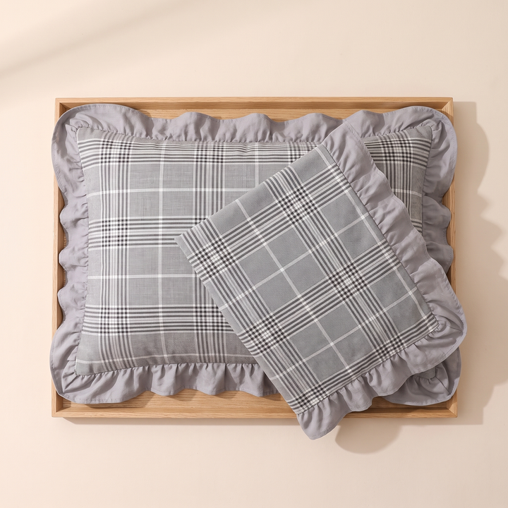 Cotton Pillowcases – Ruffled Plaid, Set of 2 in Gray Plaid – overlapping pair laid flat in a wooden tray, overhead view