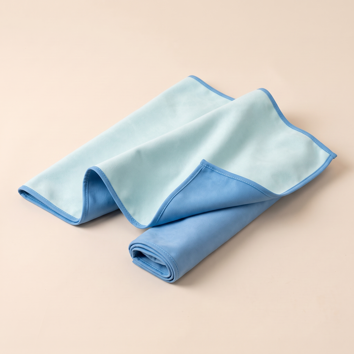 Sand-Free Beach Towel – Quick-Dry in Aqua &amp; Blue – casually layered in an s-shaped fold on a peach backdrop