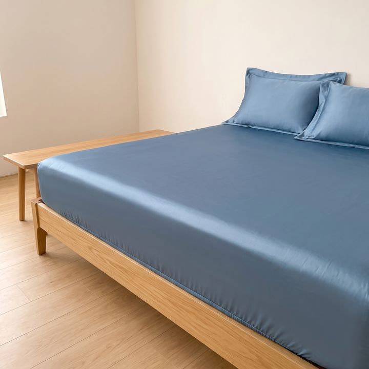 Sateen Fitted Sheet Set with 2 Pillowcases in Denim Blue – beside a long wooden bench on light wood flooring