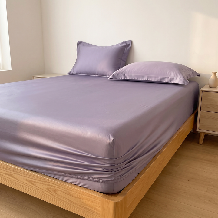 Sateen Fitted Sheet Set with 2 Pillowcases in Lavender – pillows staggered at the head, small vase on nightstand
