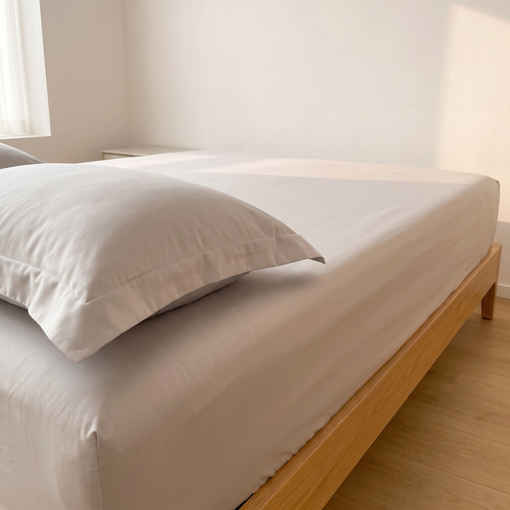 Sateen Fitted Sheet Set with 2 Pillowcases in Light Gray – low angle of pillowcase with flat border resting on mattress