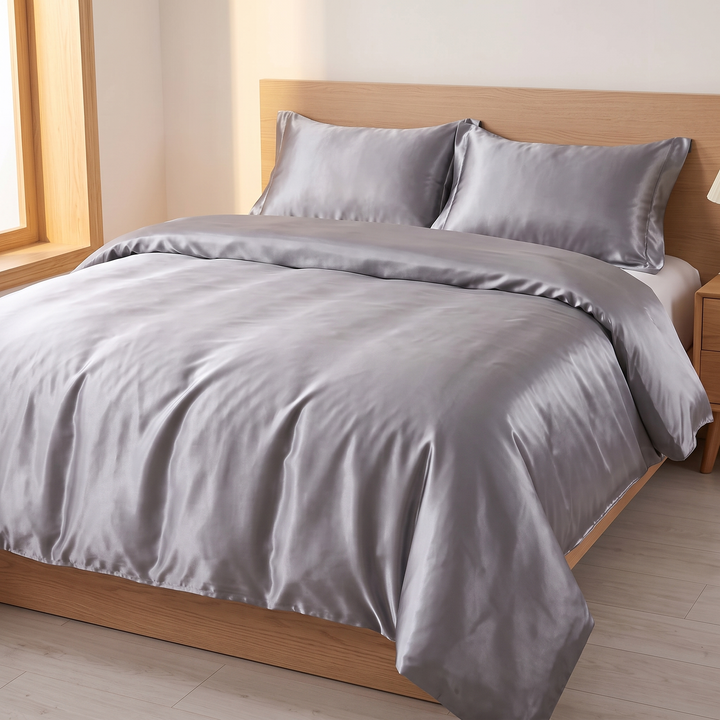Satin Bedding Set – Duvet Cover with Pillow Shams in Gray – angled view of two shams against a wooden headboard