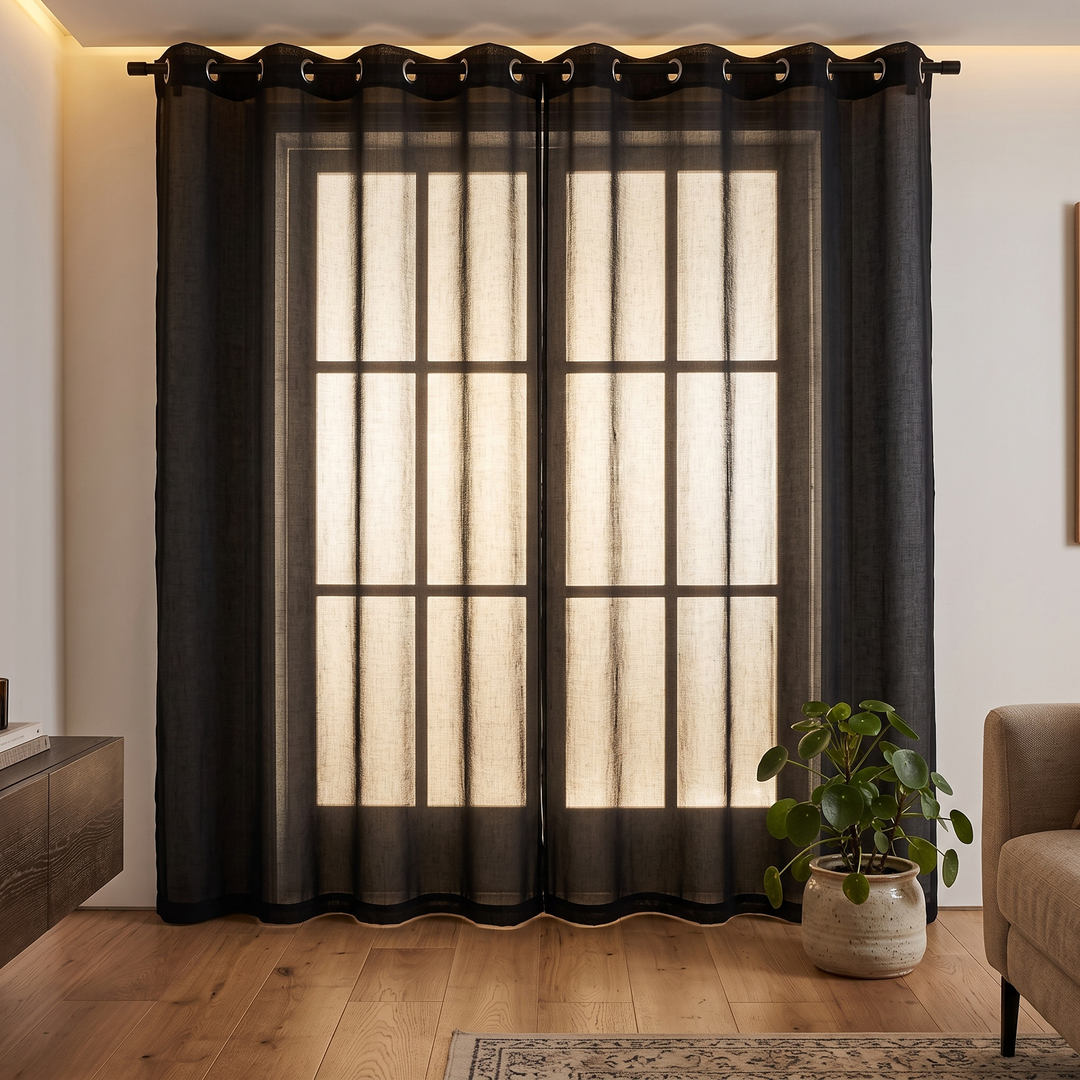 Sheer Voile Curtain Panel – Grommet Top in Black – full-length in a warm living room with potted plant