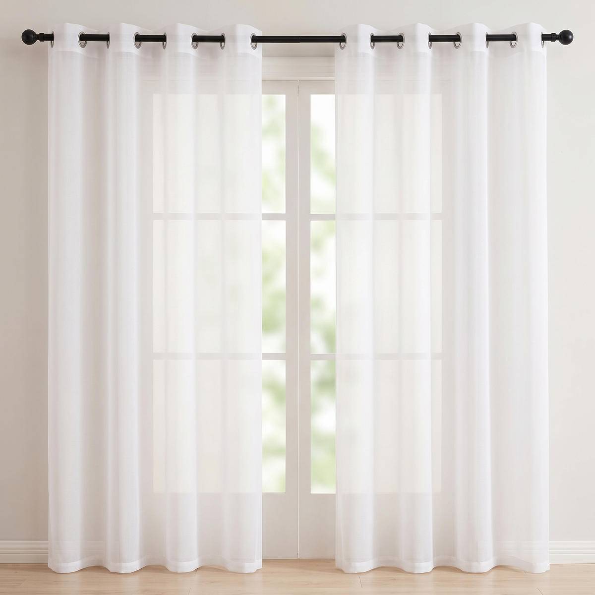 Sheer Voile Curtain Panel – Grommet Top in White – two panels hung on a black rod in front of a window