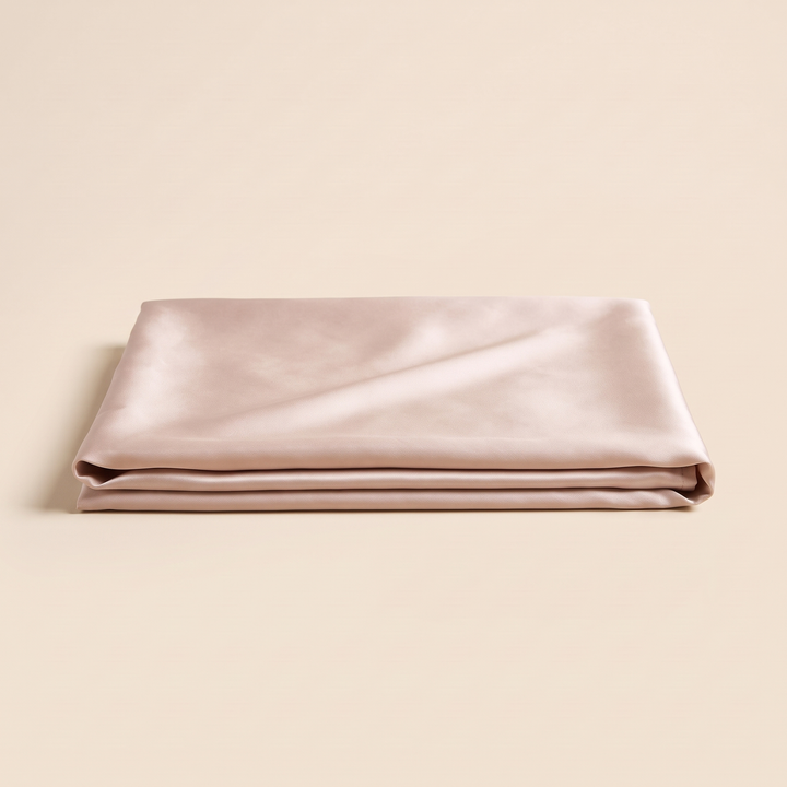 Silk Pillowcase – 19 Momme in Beige – low side view of neatly folded layers on plain backdrop