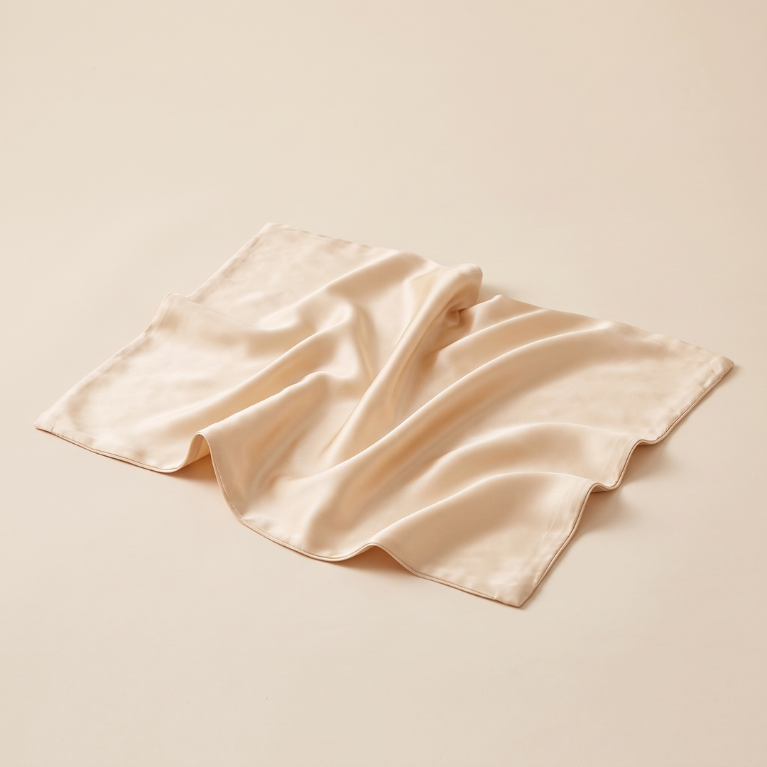 Silk Pillowcase – 19 Momme in Champagne – loosely rumpled with soft folds on a plain beige surface