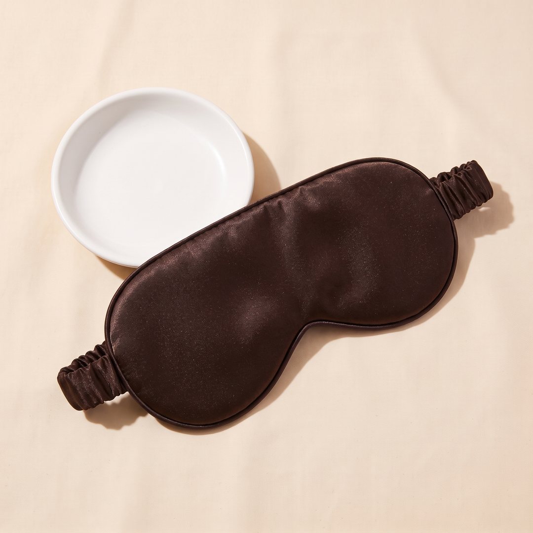 Silk Sleep Mask in Dark Brown – lying beside a small empty white ceramic dish