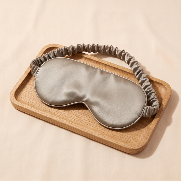 Silk Sleep Mask in Sand – resting on a small wooden tray, shot at an angle