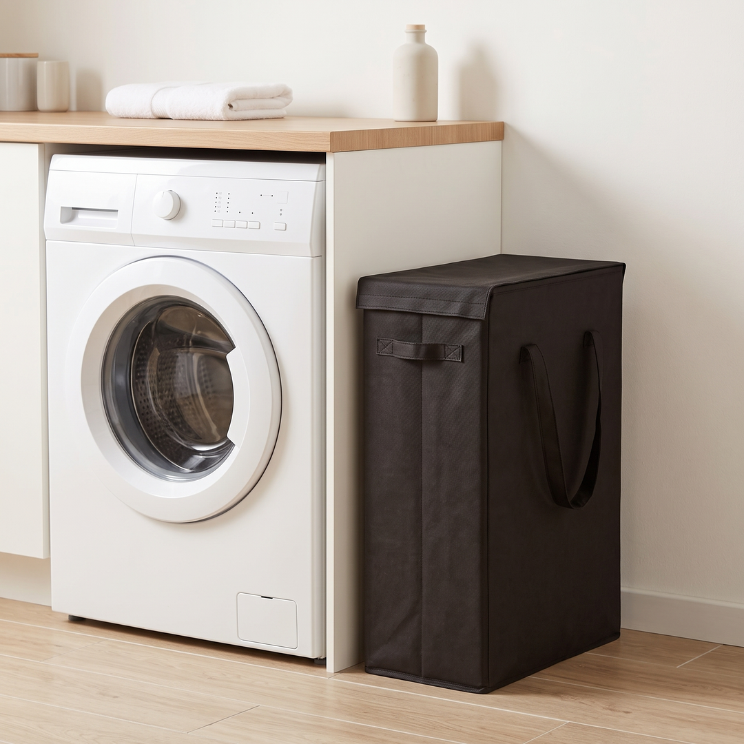 Slim Laundry Basket with Lid in Black – beside a front-loading washing machine in a laundry room
