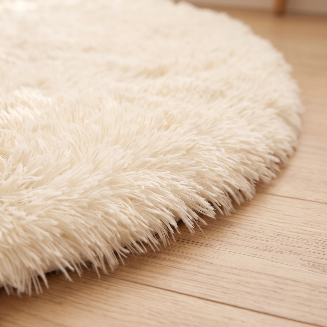 Small Round Shag Rug in Cream – close-up of the long fluffy pile edge against wooden planks