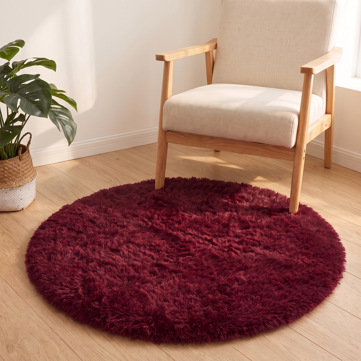 Small Round Shag Rug in Burgundy – edge tucked under front legs of a linen accent chair