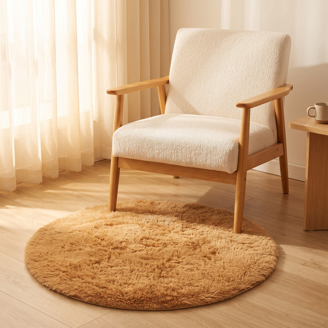 Small Round Shag Rug in Caramel – under a wooden armchair with cream cushions by sheer curtains