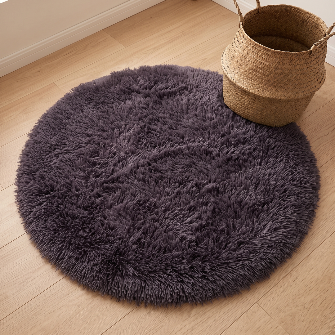 Small Round Shag Rug in Dark Purple – angled view on a wood floor with a woven basket at the edge