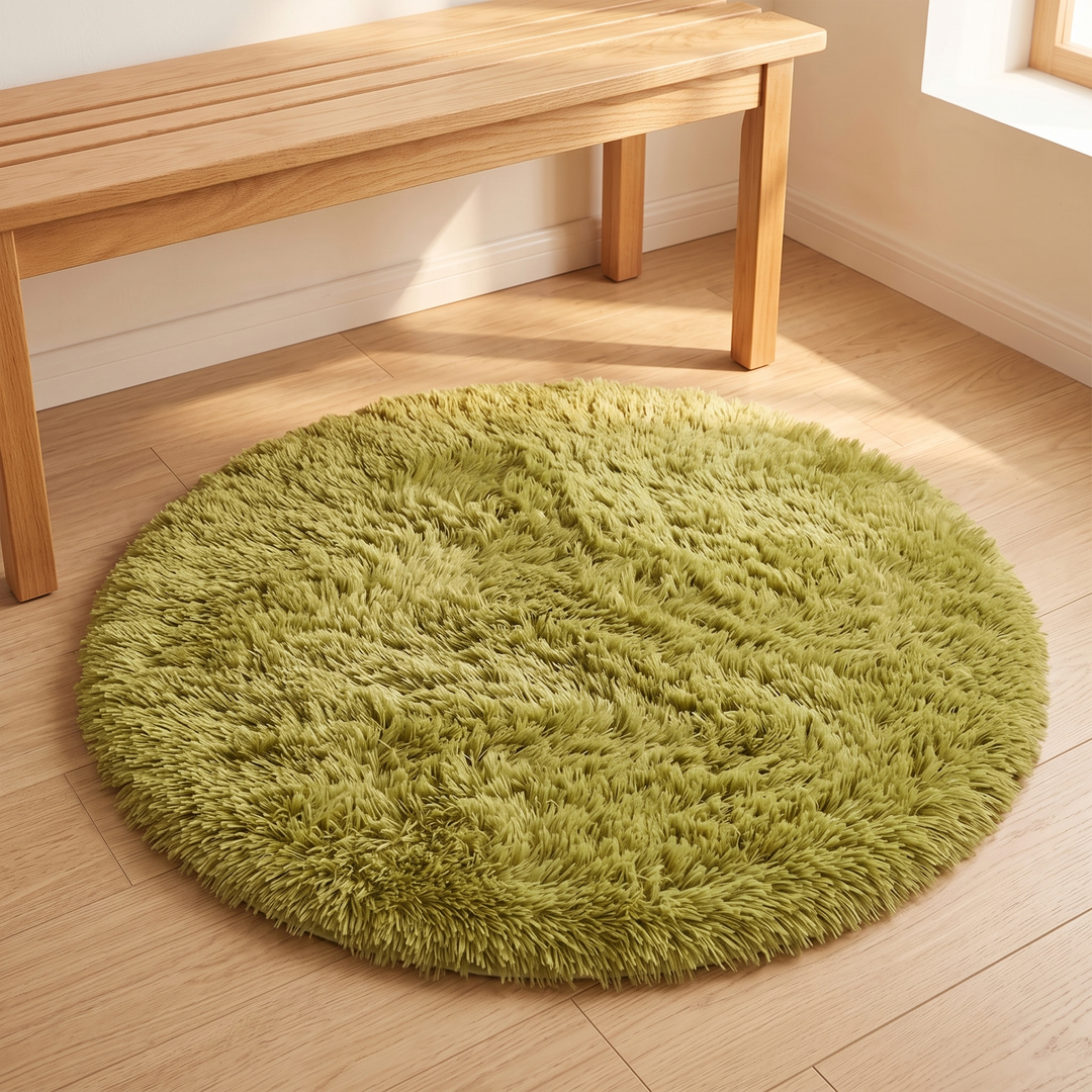 Small Round Shag Rug in Moss Green – beside a slatted wooden bench along a white wall