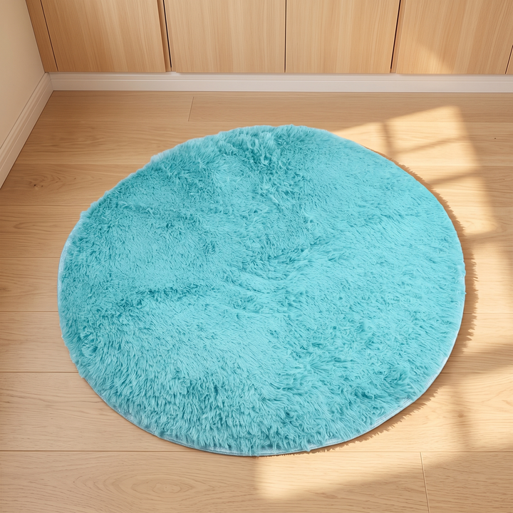 Small Round Shag Rug in Turquoise – laid on a wood floor in front of wooden cabinets