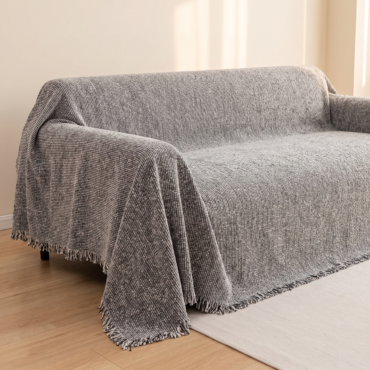 Speckled Chenille Couch Cover with Fringe in Gray – draped over a sofa in a sunlit room