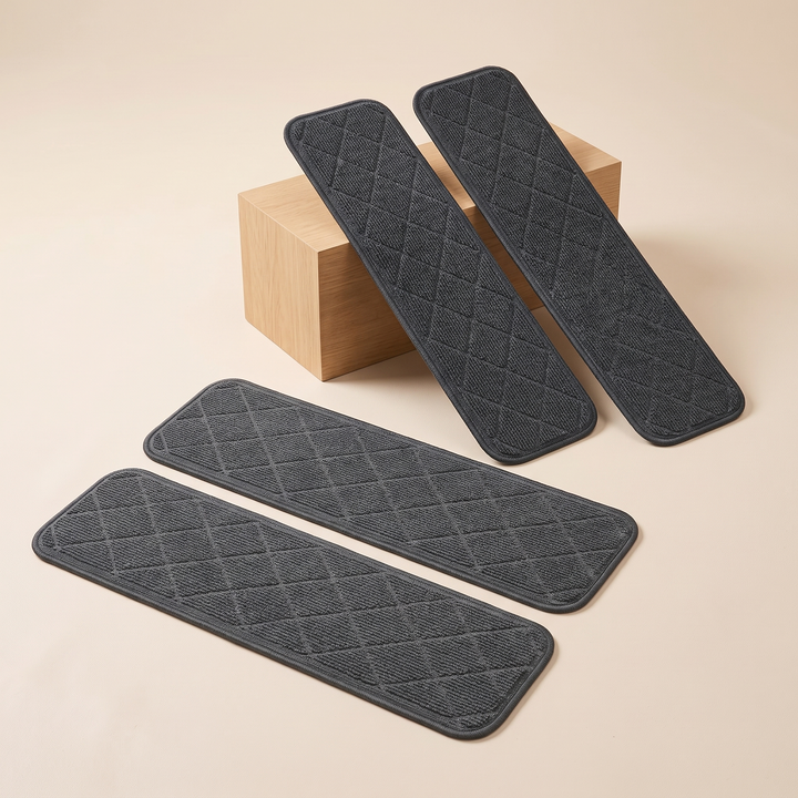 Carpet Stair Treads – Non-Slip, Self-Adhesive in Dark Gray – two leaning against a wooden block, two flat on a beige surface
