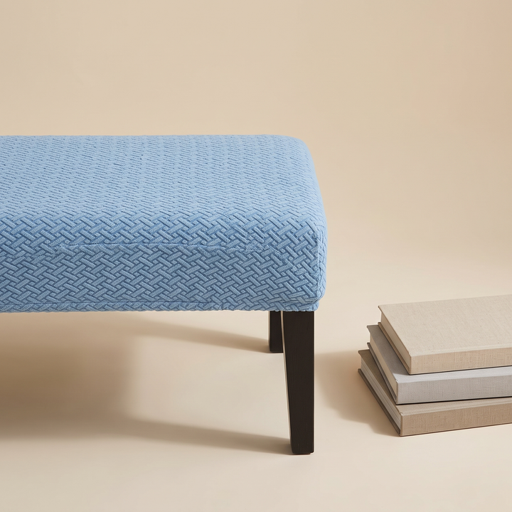 Stretch Bench Seat Cover – Jacquard in Light Blue – beside a stack of three books on a studio floor