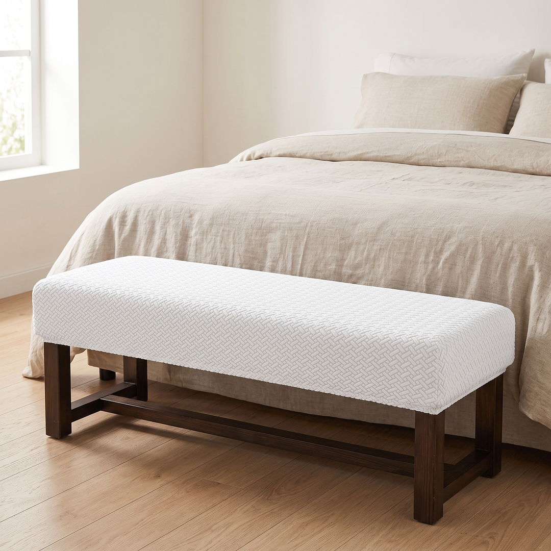 Stretch Bench Seat Cover – Jacquard in White – at the foot of a neatly made bed in a bright bedroom