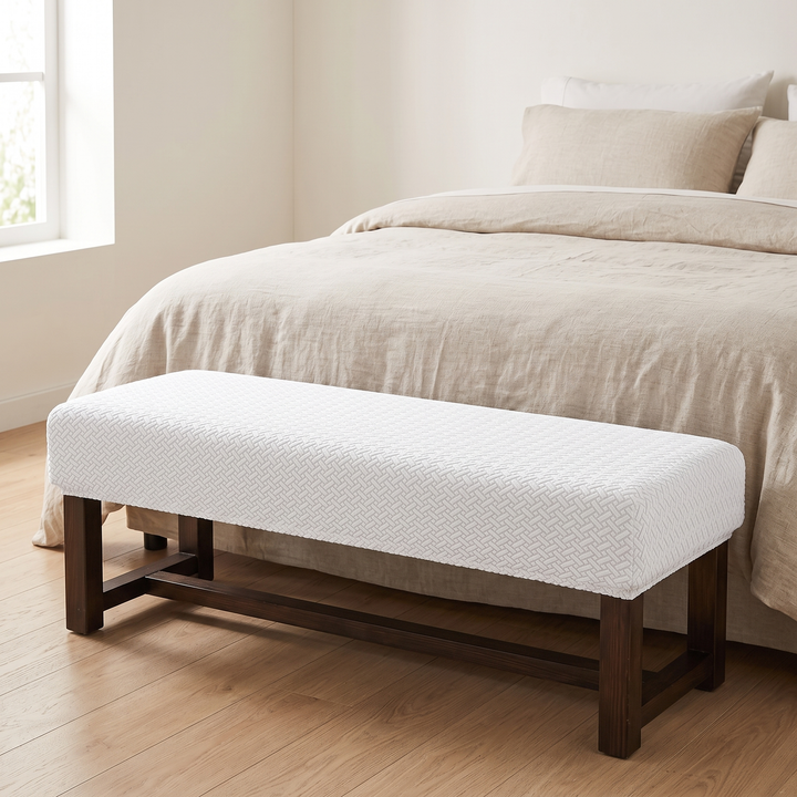 Stretch Bench Seat Cover – Jacquard in White – at the foot of a neatly made bed in a bright bedroom
