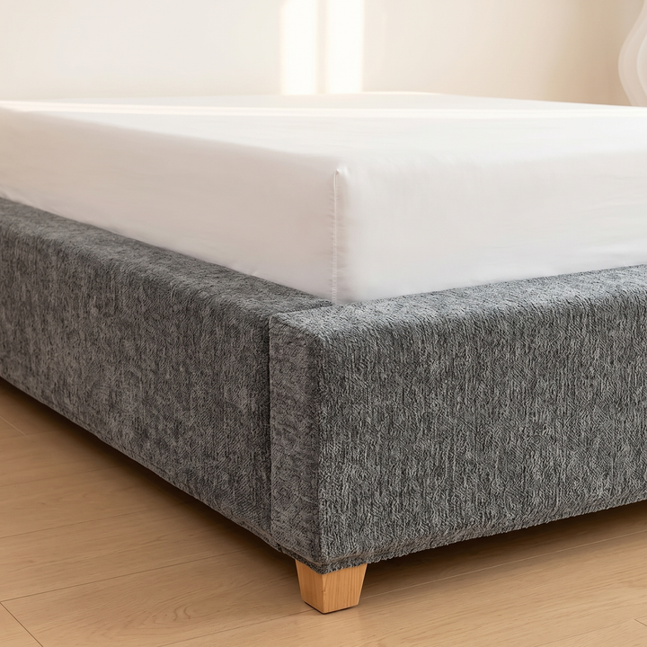 Stretch Box Spring Cover in Gray – close-up of a bed corner on a wood floor